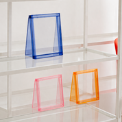 Lana Photo Frames in clear acrylic with blue, pink and orange neon edges on glass shelving
