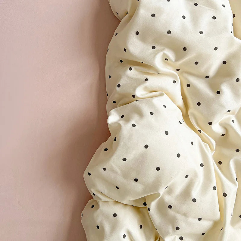 Close-up of rumpled cream fabric with black spot pattern from the Lenny Spot Bedding Set