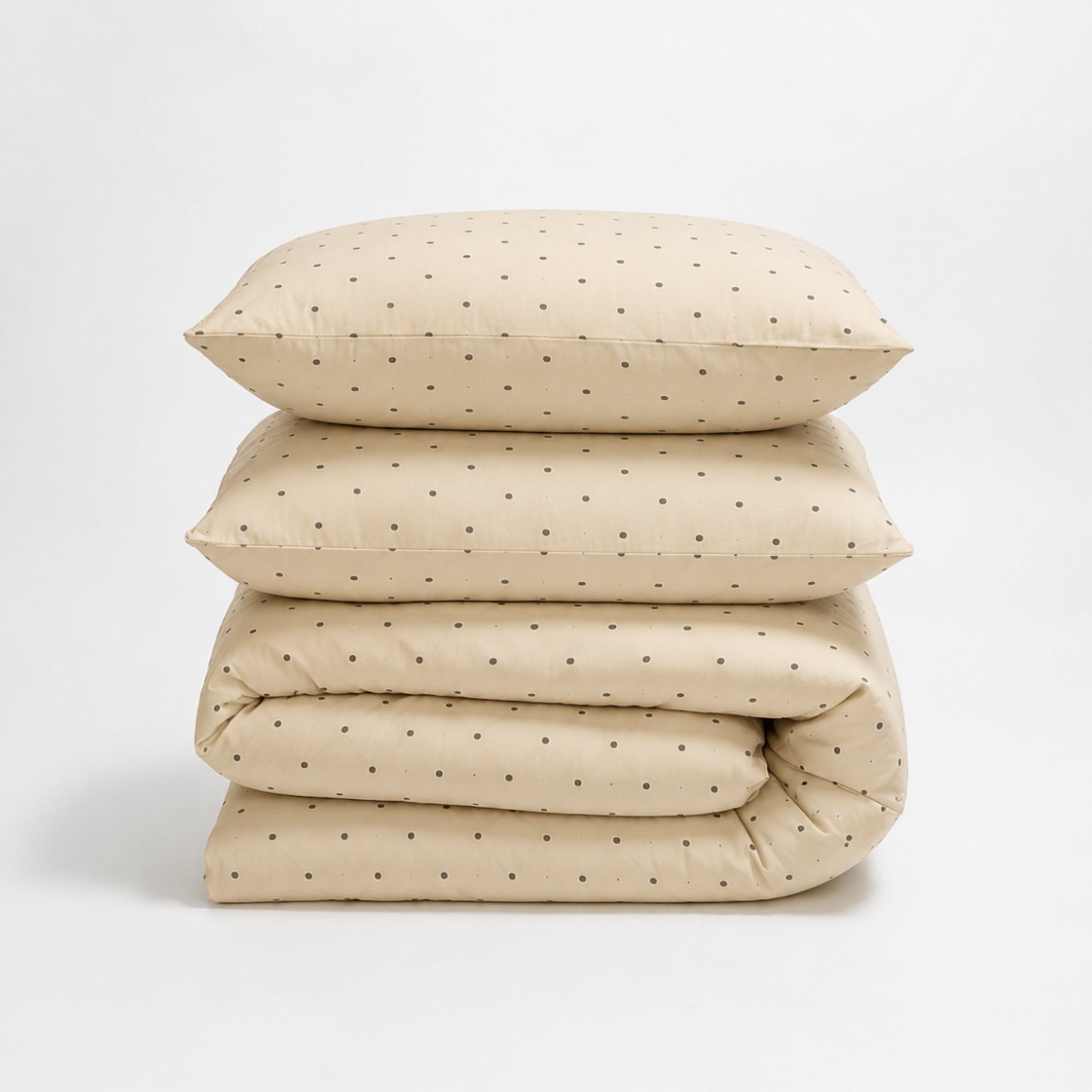 Lenny Spot Bedding Set folded in a stack, cream fabric with fine grey spot pattern, on white