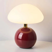 Lumi Mushroom Table Lamp in Wine Red, glossy round base and domed milk-glass shade lit warm