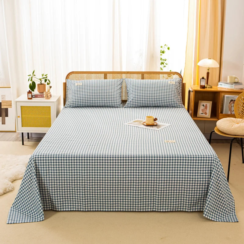 Luna Cotton Flat Sheet in Indigo Grid, small gingham check dressing a rattan bed with matching pillowcases