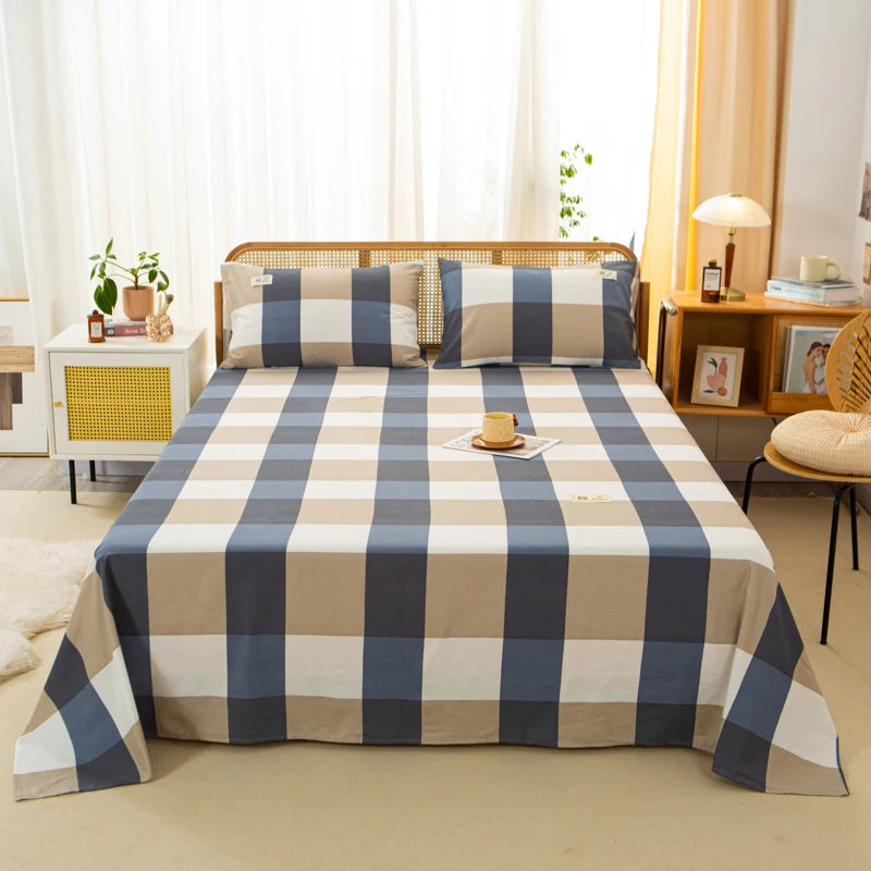 Luna Cotton Flat Sheet in Navy Picnic, bold check pattern dressing a rattan bed with matching pillowcases
