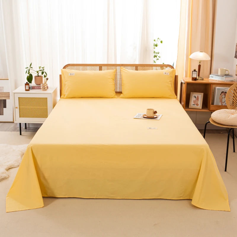 Luna Cotton Flat Sheet in Sunbeam, made up on a bed with matching pillowcases in a sunny bedroom