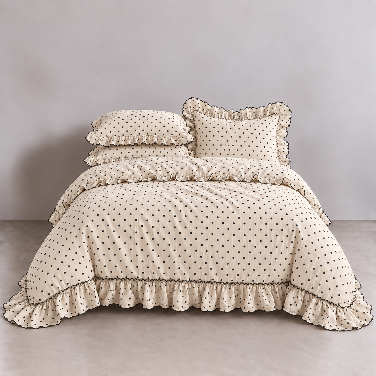 Mable Spot Bedding Set in Cocoa, cream twill with dark spots and gathered ruffle trim on a made bed