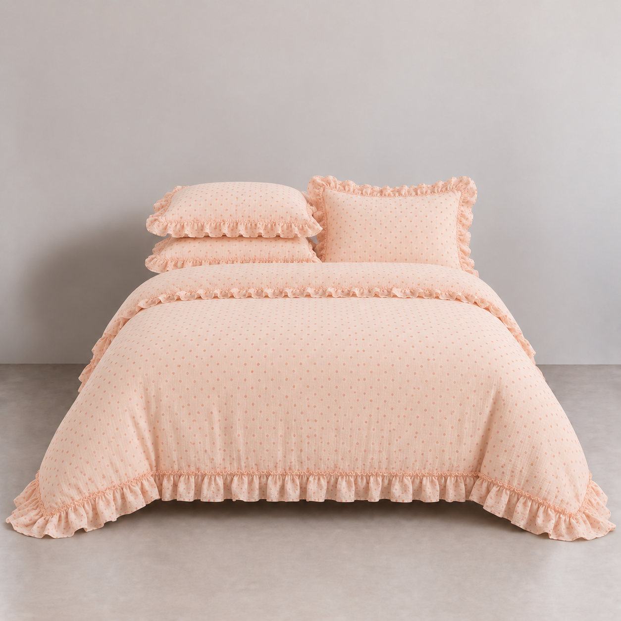 Mable Spot Bedding Set in Peach on a made bed, with ruffled edges and soft spot print