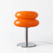 Macaron Lamp in Orange, glossy stacked glass shade on a polished chrome base against white