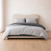 Marseille Stripe Bedding Set in Charcoal Vanilla, grey striped quilt cover styled on a bed with charcoal sheet