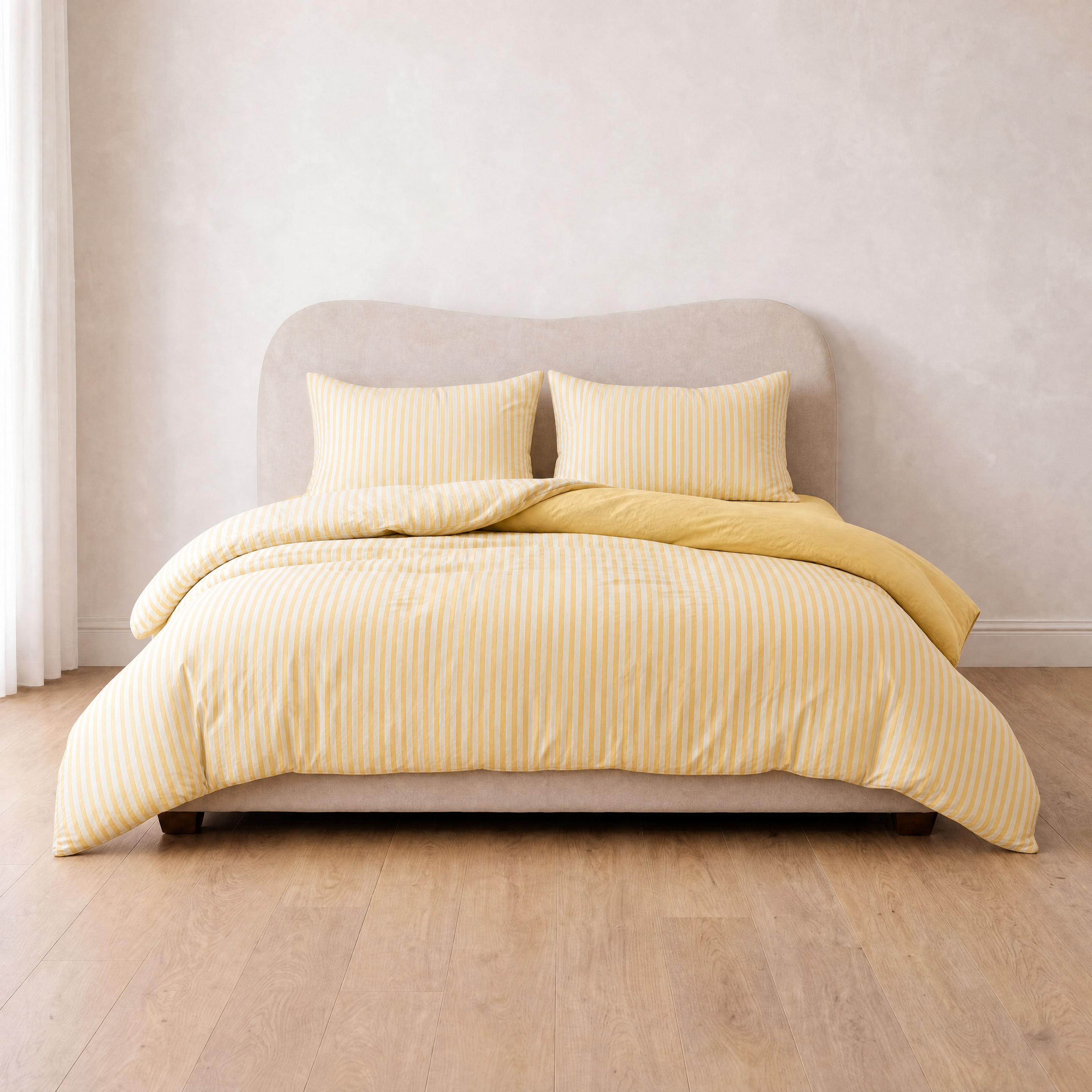 Marseille Stripe Bedding Set in Lemon Butter, striped quilt cover on a made bed with folded-back corner