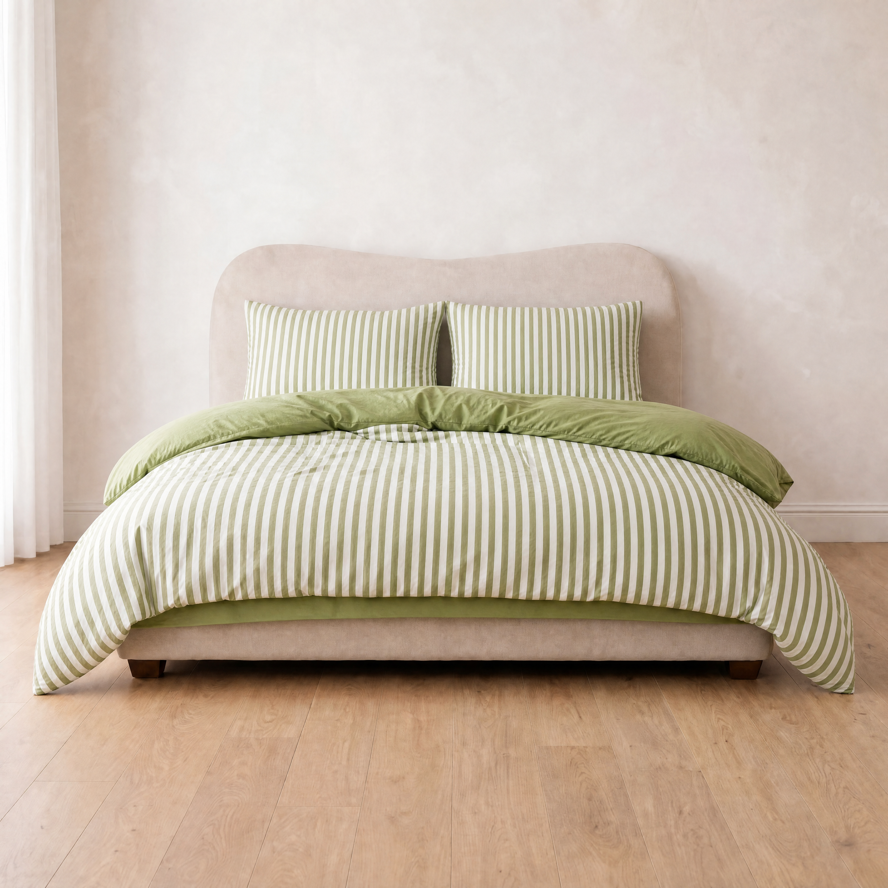 Marseille Stripe Bedding Set in Pistachio Cream, green and white stripes on a made bed with solid green reverse