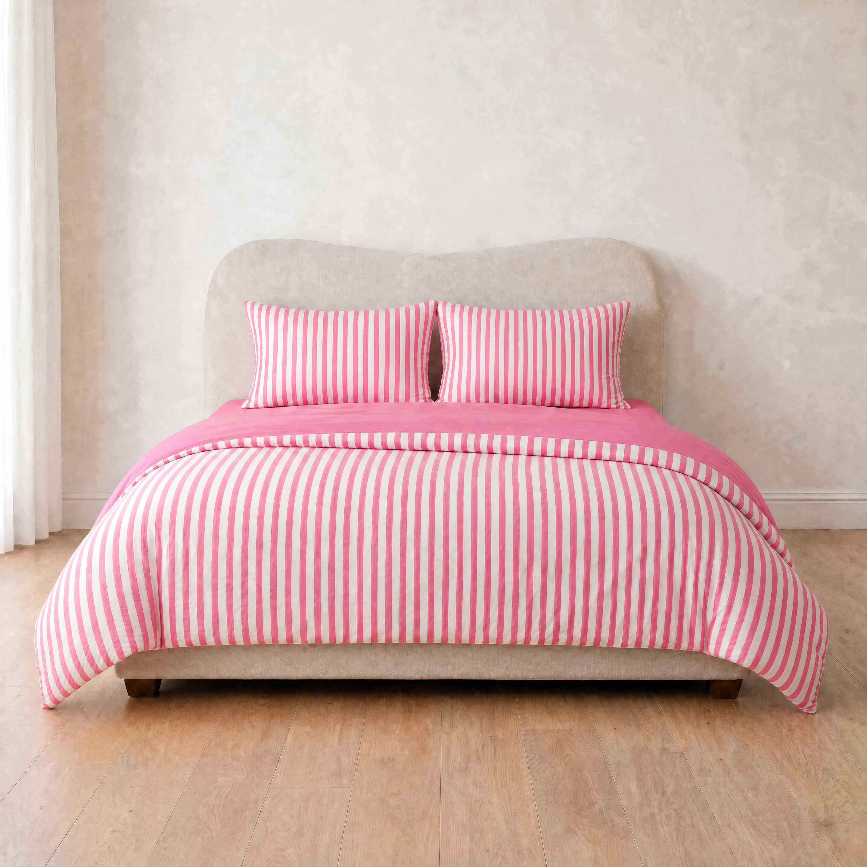 Marseille Stripe Bedding Set in Strawberry Gelato, pink and white stripes on a made bed with matching pillowcases