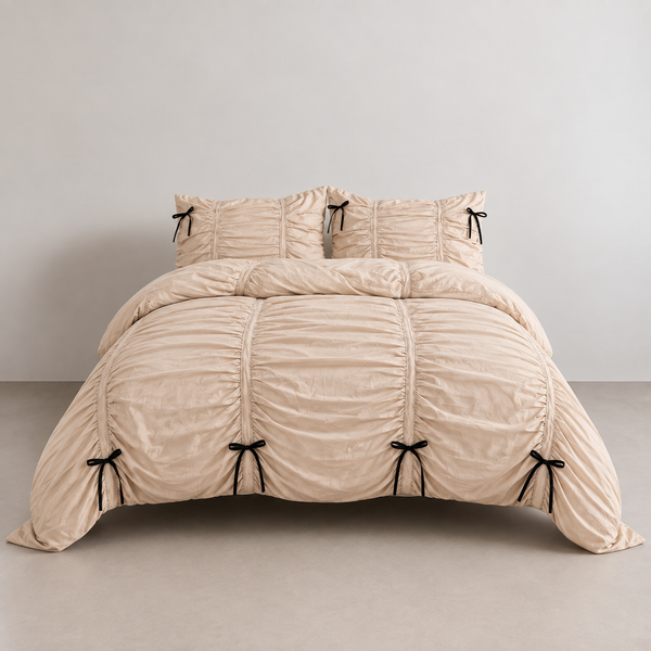 Metaya Bedding Set in Beige, ruched quilt cover and pillowcases on a bed with black tie details