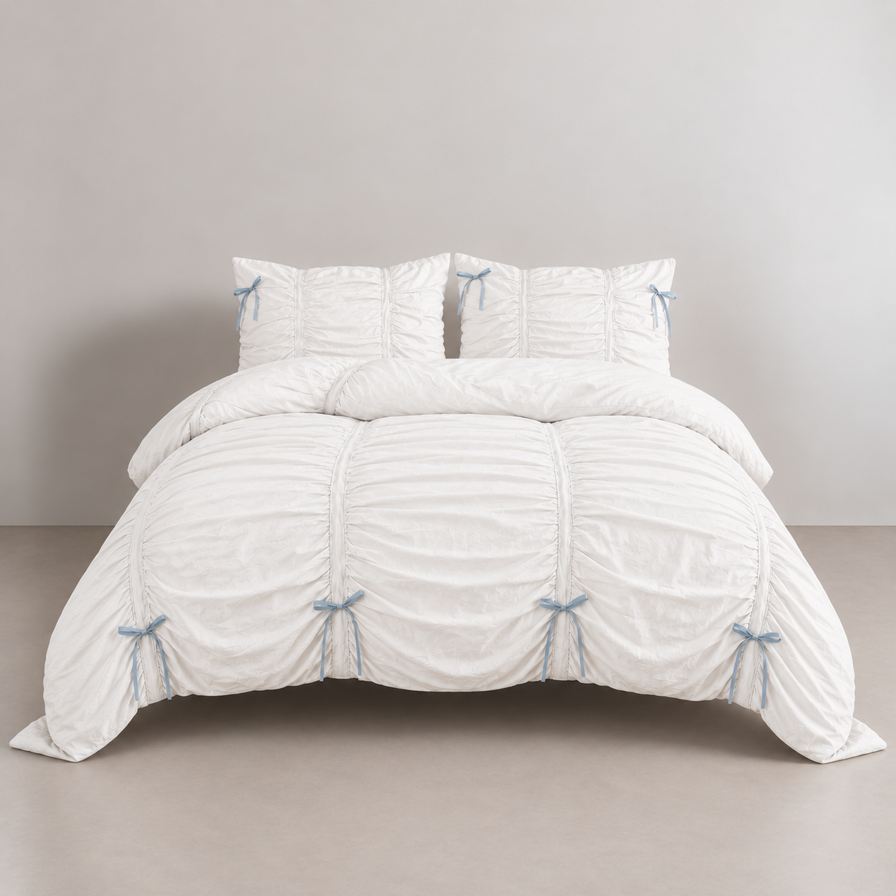 Metaya Bedding Set in Blue & White, ruched quilt cover with pale blue ribbon ties on a made bed