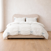 Metaya Bedding Set in Blue & White, ruched white quilt cover with pale blue tie details on a made bed