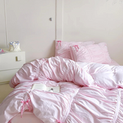 Metaya Bedding Set in Blush Pink, ruched quilt cover and pillowcases with bow ties on an unmade bed