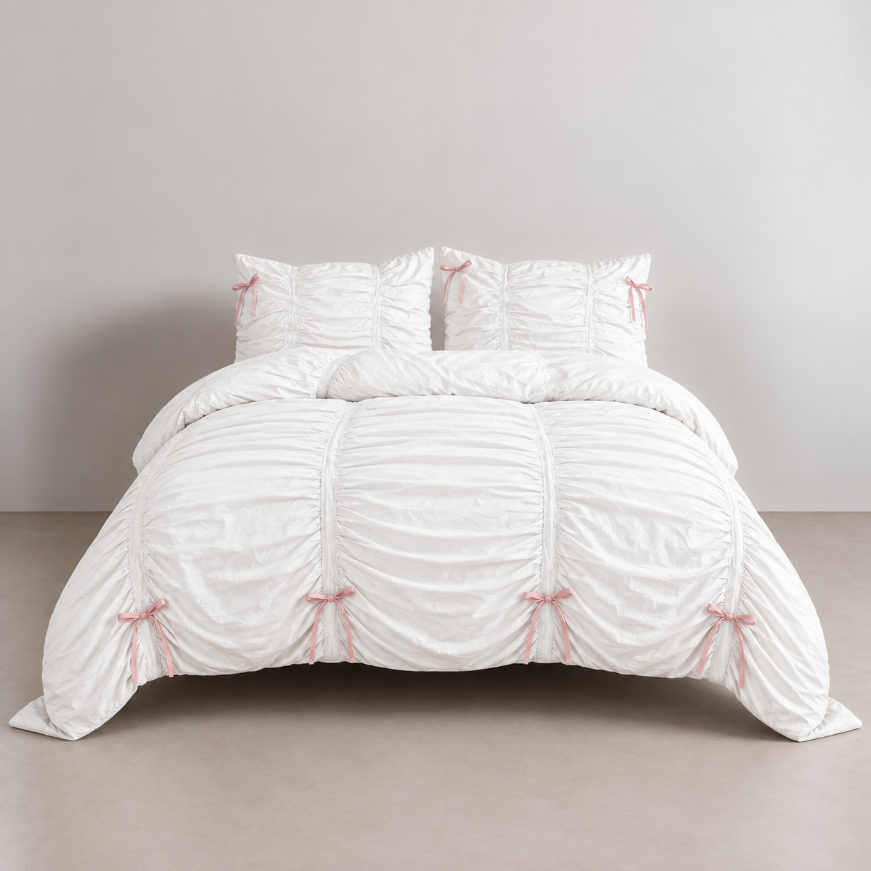 Metaya Bedding Set in Pink & White, ruched white cotton with pink ribbon ties on a made bed