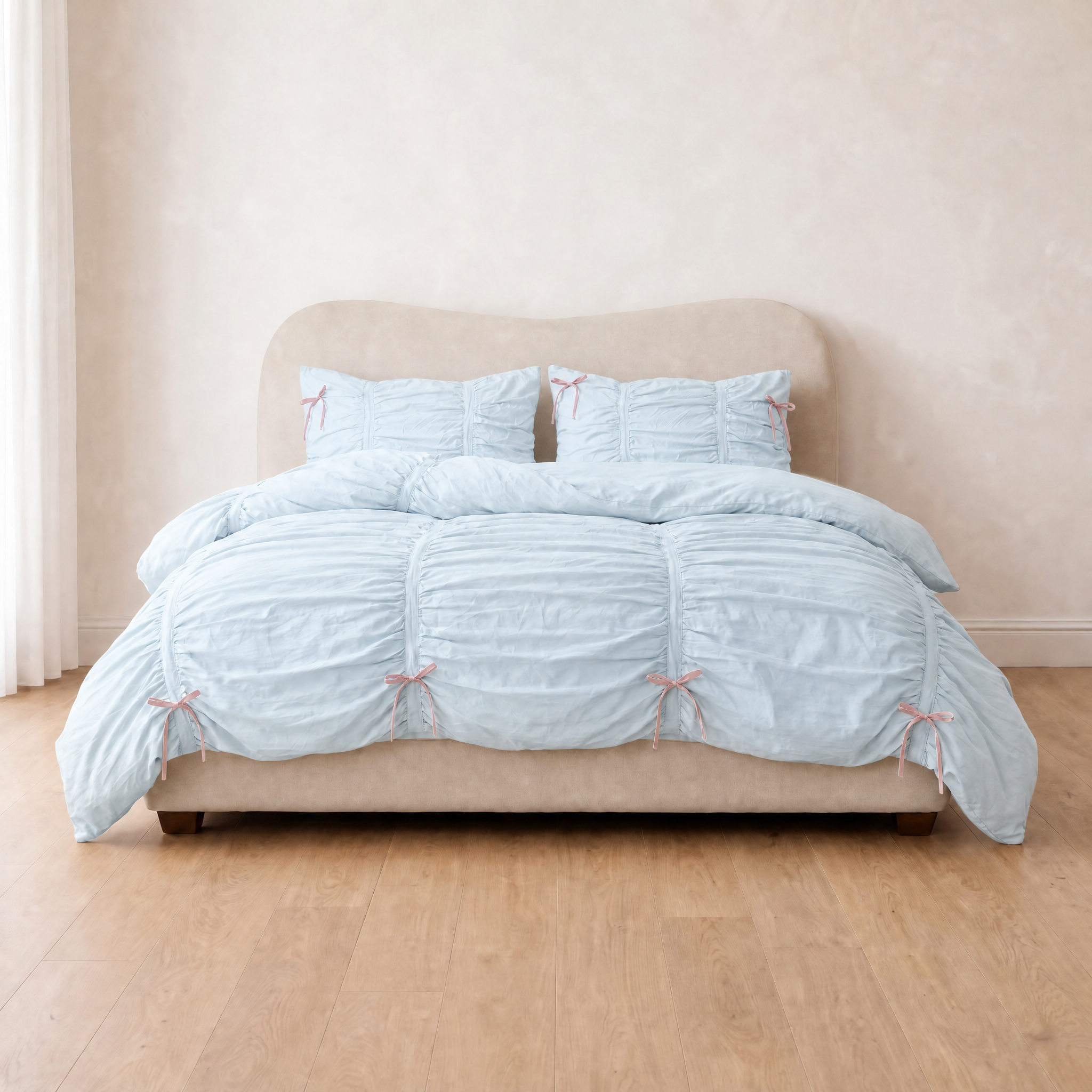 Metaya Bedding Set in Sky Blue, ruched cotton twill with pink ties, styled on a made bed