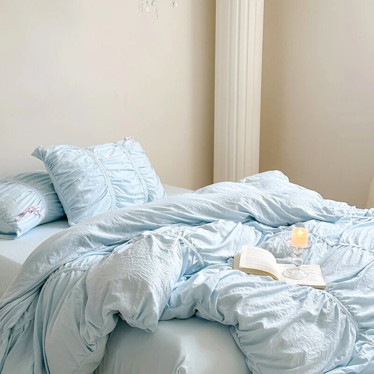 Metaya Bedding Set in Sky Blue, ruched pillowcases and rumpled quilt cover styled with a candle and open book
