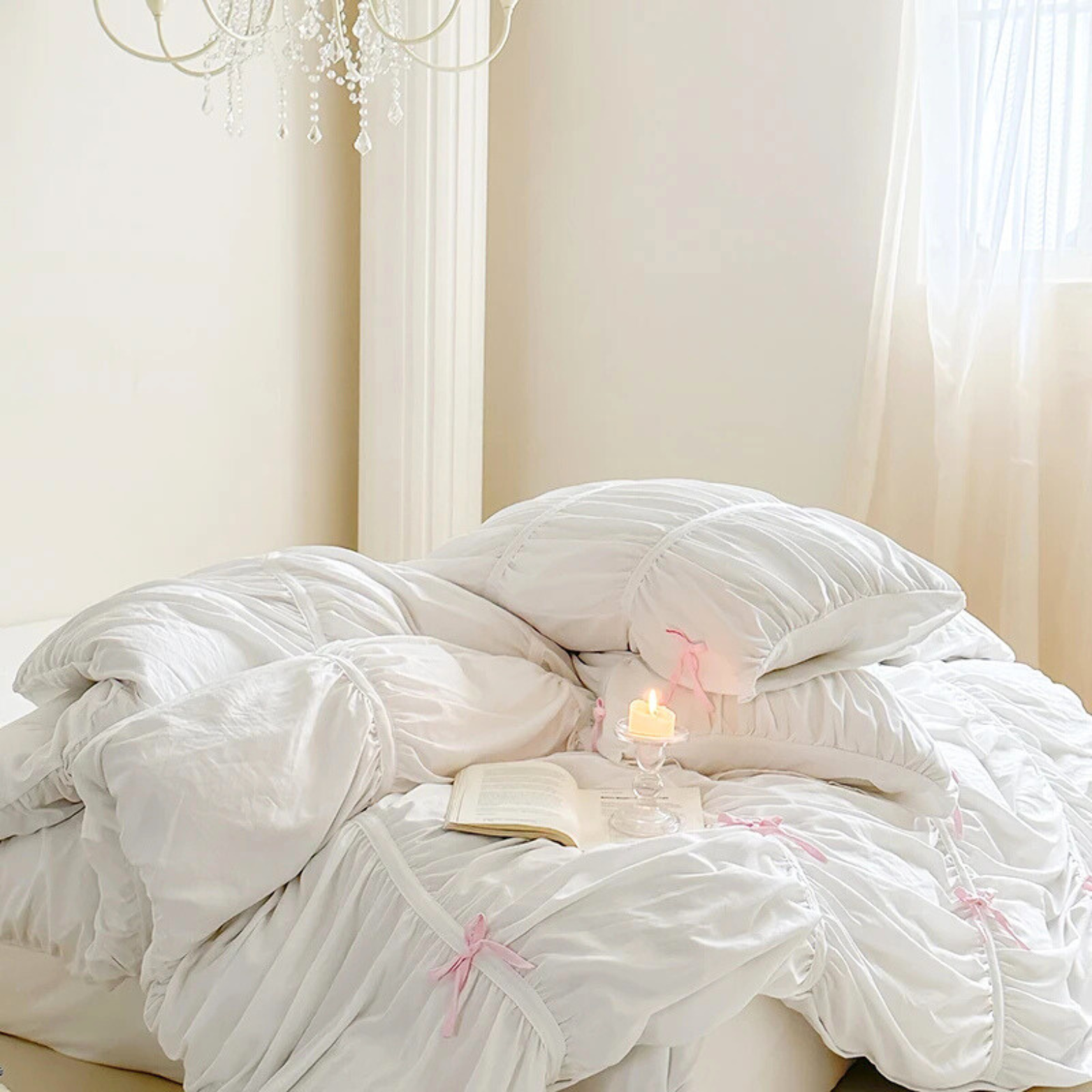 Metaya Bedding Set rumpled in white with pink bow ties, candle and open book styled on the bed