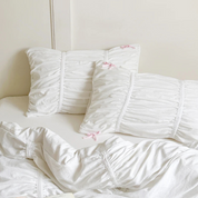 Metaya Bedding Set pillowcases in ruched white cotton twill with tiny pink bow details