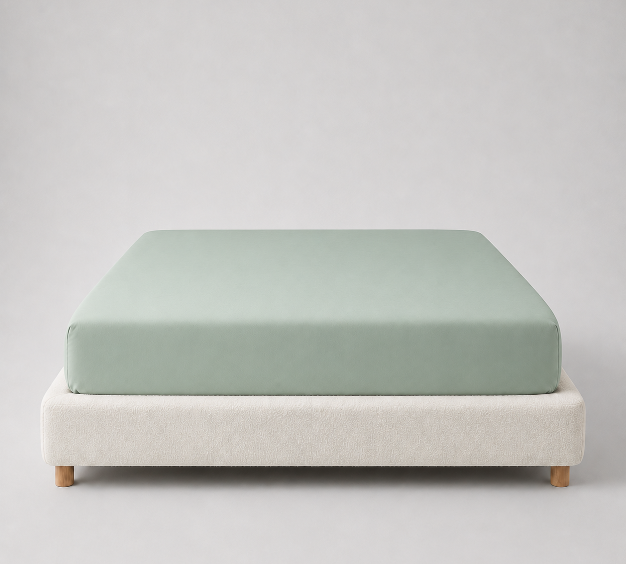 Mira Bamboo Fitted Sheet in Aqua, soft sage-green fabric fitted snugly over a mattress on a bed base