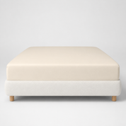 Mira Bamboo Fitted Sheet in Butter, smoothly fitted over a low platform bed base