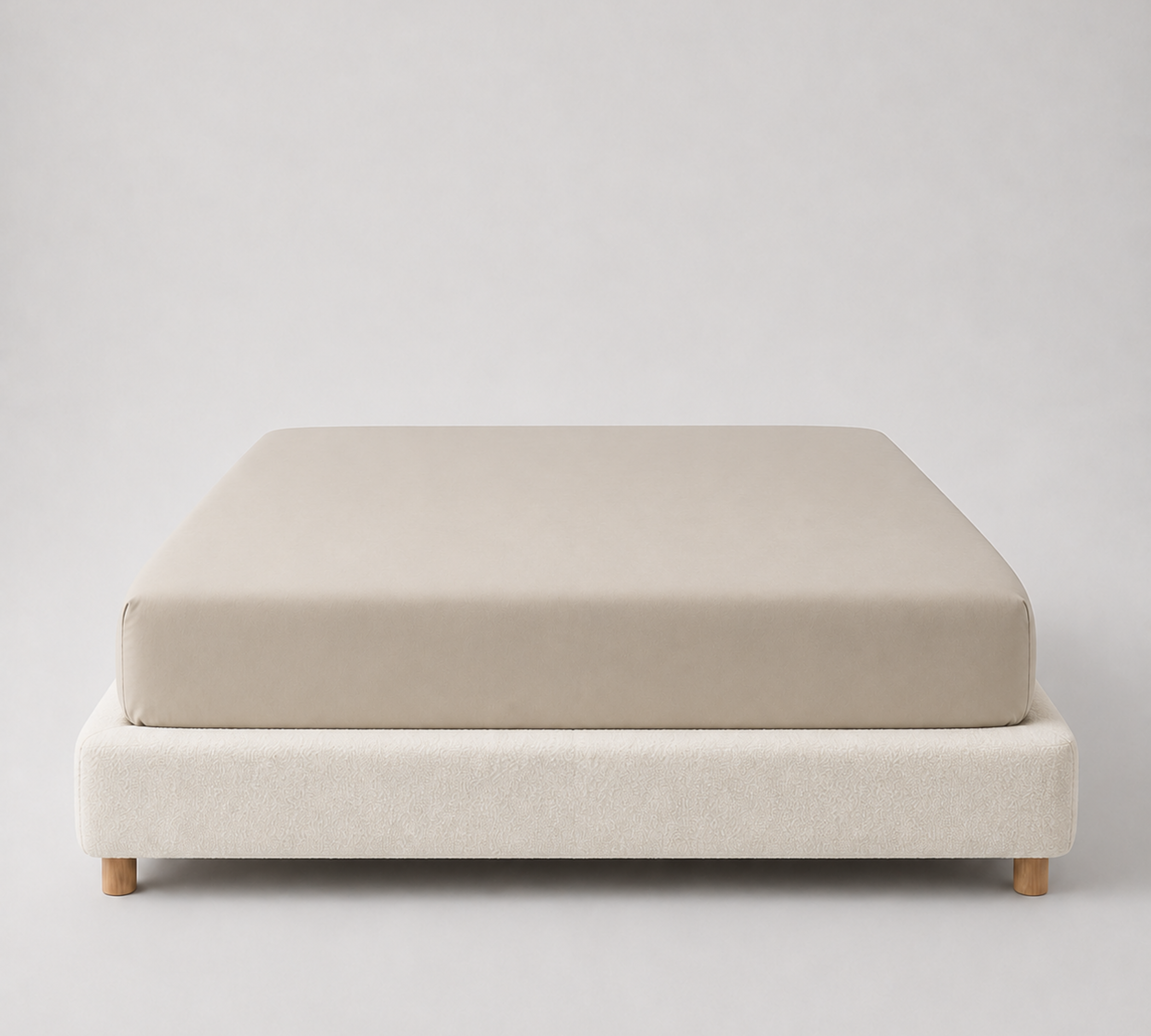 Mira Bamboo Fitted Sheet in Champagne, smooth stretched over a mattress on a wooden-leg base