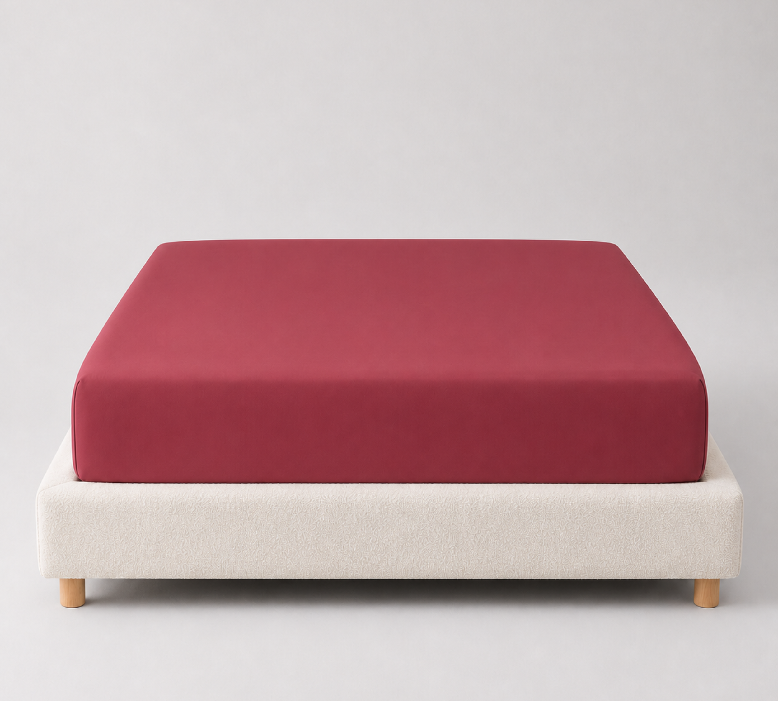 Mira Bamboo Fitted Sheet in Cherry, deep red bamboo fabric fitted snugly over a mattress base