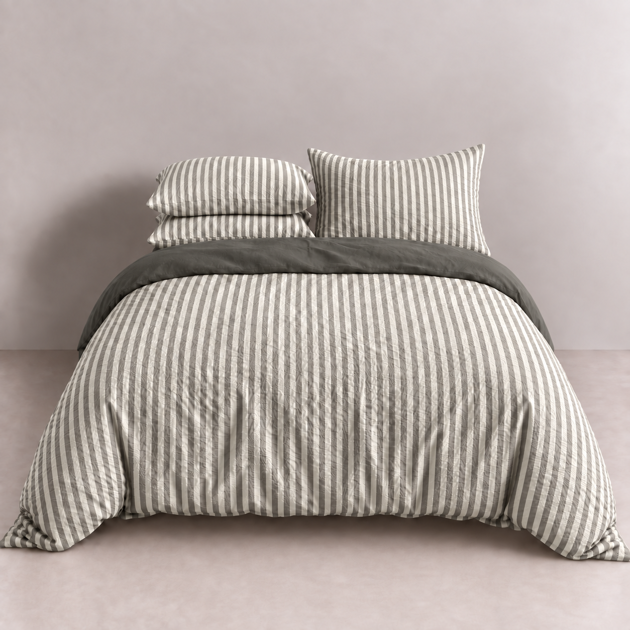 Noah Bedding Set in Ash, grey and white stripe quilt cover with matching pillowcases on a made bed