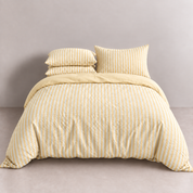 Noah Bedding Set in Butter, yellow and white stripe quilt cover styled on a made bed with matching pillowcases