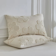 Two pillowcases from the Posie Embroidered Bedding Set, tufted floral texture on creamy neutral cotton