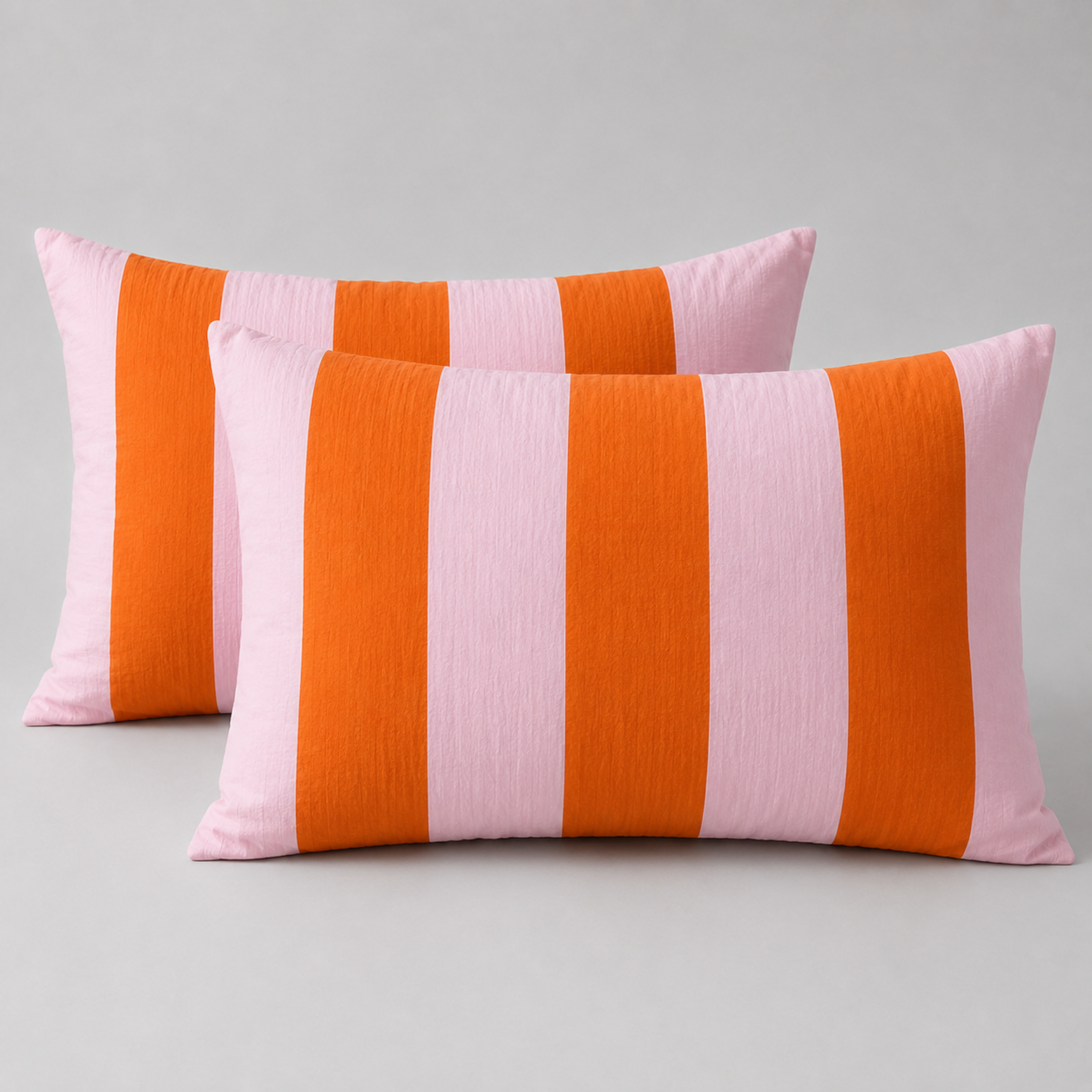 Two pillowcases from the Ravello Stripe Bedding Set, wide grapefruit pink and orange stripes, textured cotton