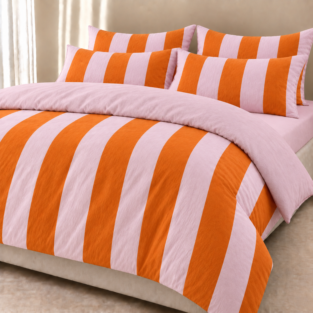 Ravello Stripe Bedding Set styled on a bed, wide orange and pink stripes with a crinkled, textured weave