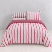 Rhodes Striped Bedding Set in Blush & Pink, made bed with pink stripes and a berry reverse trim