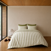 Rhodes Striped Bedding Set in Sage & Cream on a made bed, olive stripes with olive pillowcase backing