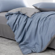 Soléa Bamboo Bedding Set in Deep Sea Blue - Grey, sateen quilt cover rumpled to show its reversible grey side