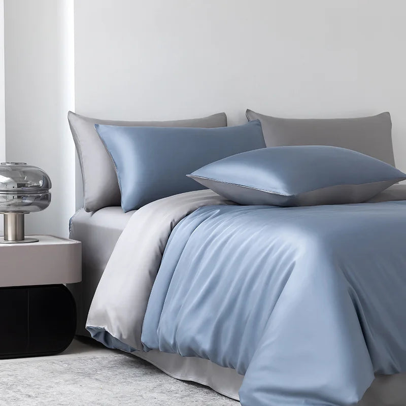 Soléa Bamboo Bedding Set in Deep Sea Blue - Grey, sateen quilt cover styled on a bed with mixed pillowcases