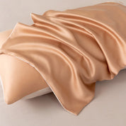 Close-up of a pillowcase from the Soléa Bamboo Bedding Set, warm gold sateen draped in soft folds