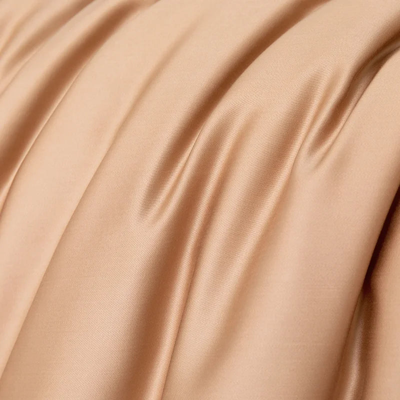 Close-up of the Soléa Bamboo Bedding Set in warm beige, showing the sateen weave's smooth sheen and soft folds