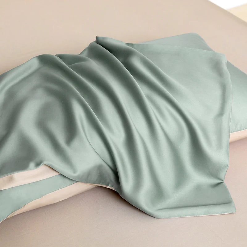 Soléa Bamboo Bedding Set in sage green, sateen fabric draped over pillows showing its smooth sheen