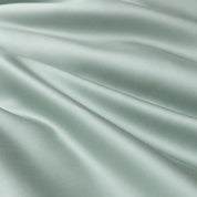 Close-up of sage green sateen fabric from the Soléa Bamboo Bedding Set, showing its smooth sheen and soft folds
