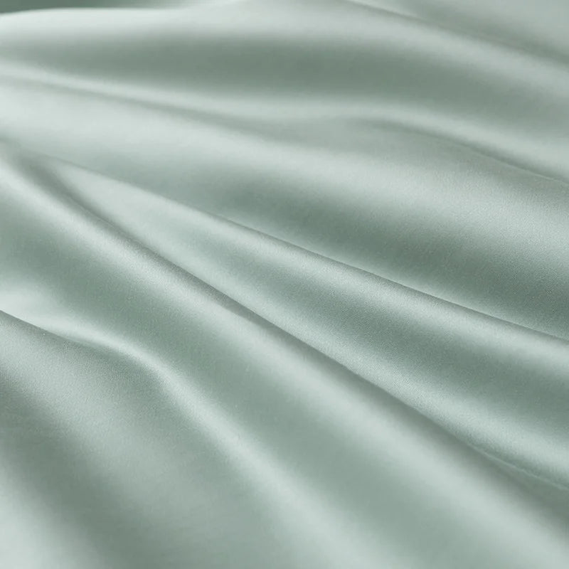 Close-up of sage green sateen fabric from the Soléa Bamboo Bedding Set, showing its smooth sheen and soft folds