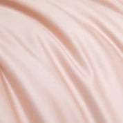 Close-up of the Soléa Bamboo Bedding Set in soft blush pink, showing its smooth sateen sheen and drape