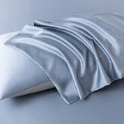 Close-up of Soléa Bamboo Bedding Set in pale blue-grey sateen, draped over a pillow to show its smooth sheen
