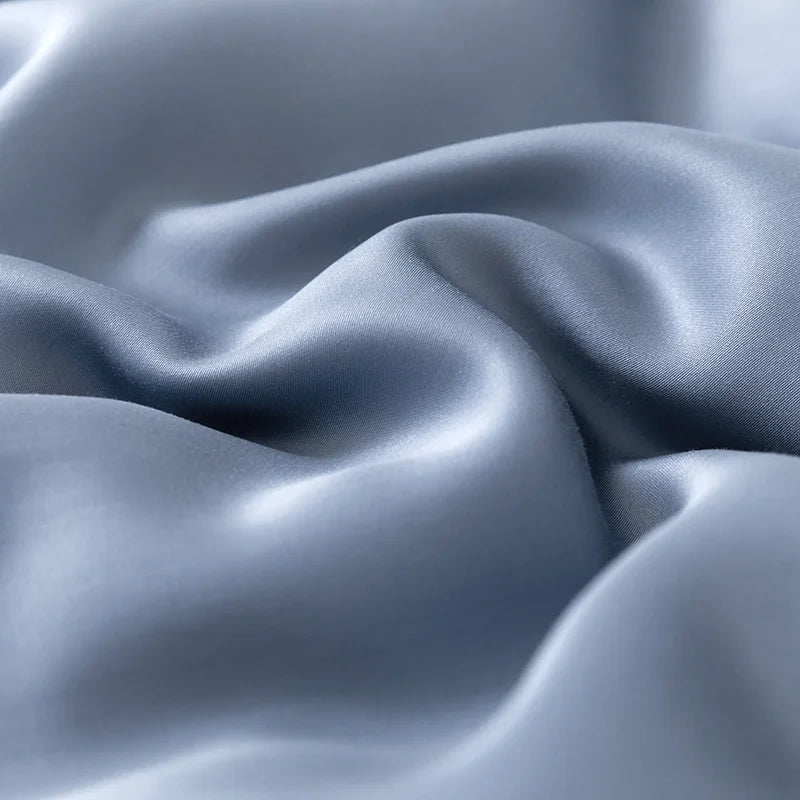 Close-up of the Soléa Bamboo Bedding Set in dusty blue, showing soft sateen sheen and gentle folds
