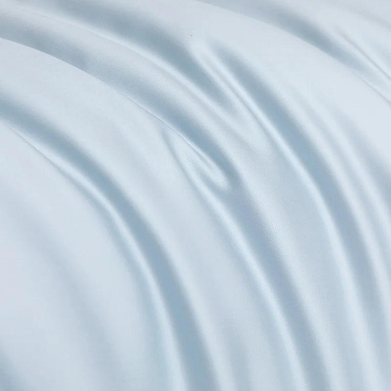 Close-up of the Soléa Bamboo Bedding Set in pale blue, showing soft draped folds and a smooth sateen sheen