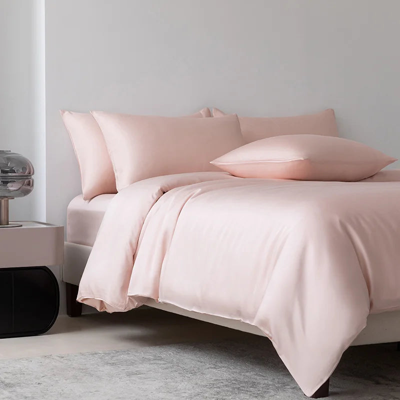 Soléa Bamboo Bedding Set in Love Pink, soft blush sateen dressing a bed beside a marble nightstand