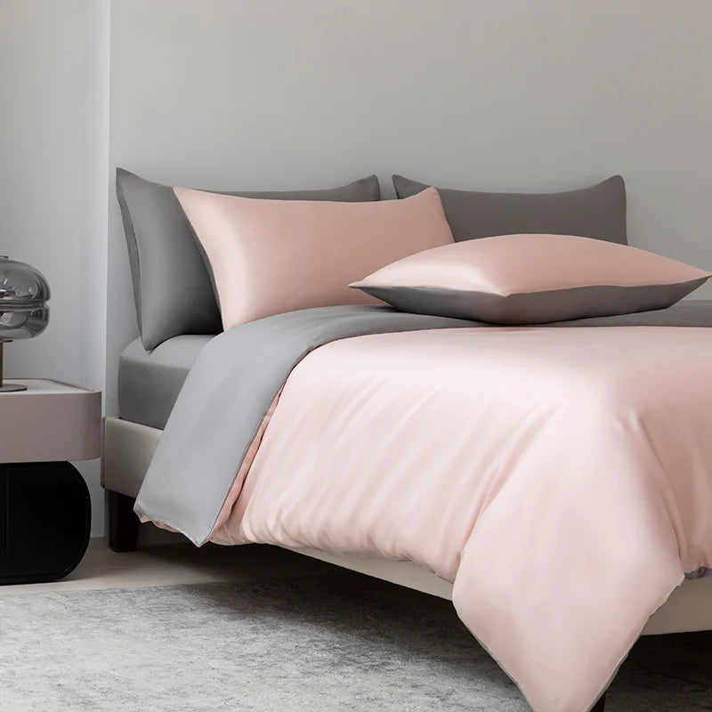 Soléa Bamboo Bedding Set on a made bed, blush pink quilt cover reversing to soft grey, sateen sheen