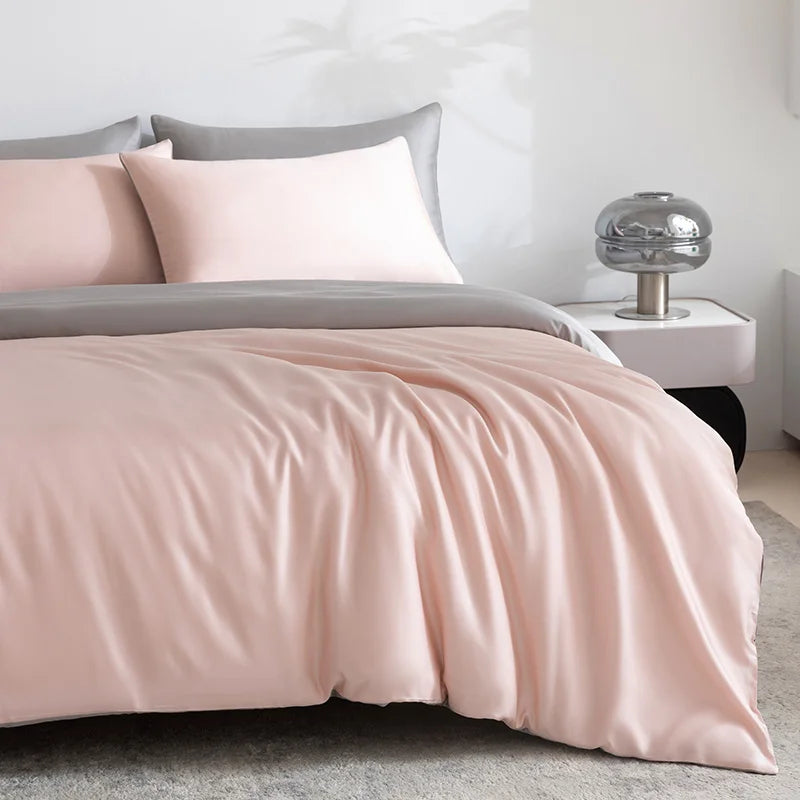 Soléa Bamboo Bedding Set in blush pink with grey reverse, sateen sheen draping loosely on a made bed