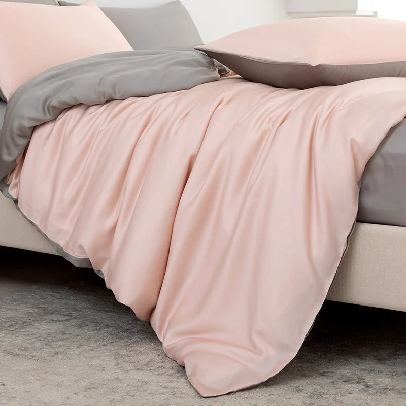 Soléa Bamboo Bedding Set draped over a bed corner, soft pink sateen with grey reverse showing
