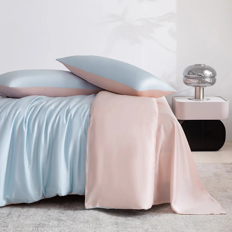 Soléa Bamboo Bedding Set styled with soft blue and blush pink sateen, draped over a made bed